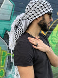 Palestine Man wearing keffiyeh and plain black shirt streetwear with graffiti background